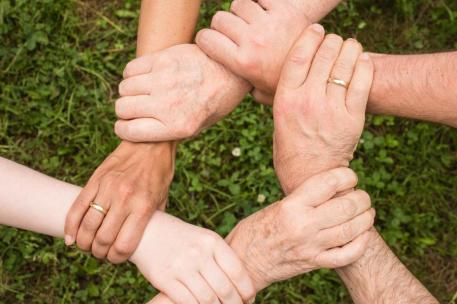 seis manos agarrándose unas a otras hasta formar un hexágono